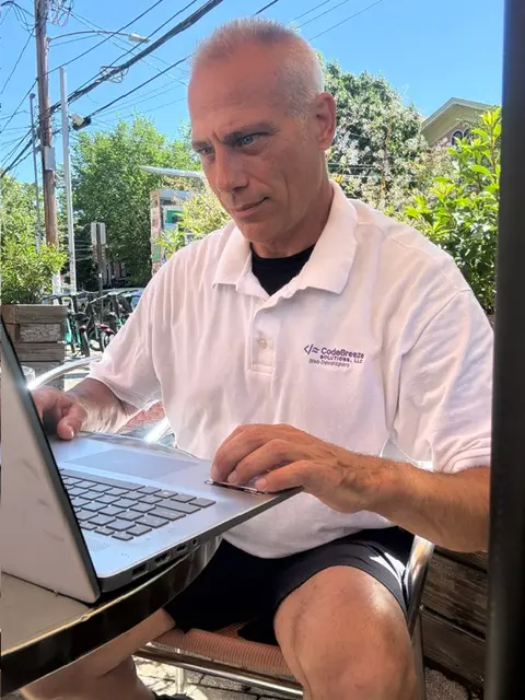 Kevin Mohan working on a laptop for CodeBreeze Solutions