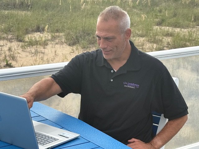 Kevin Mohan working on a laptop outdoors